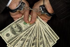 Person Handcuffed Holding Cash
